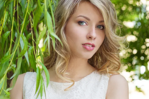 Portrait of a beautiful sexy girl with big full lips, with white hair in a white dress near a tree — Stock Photo, Image