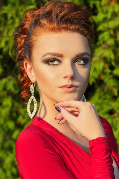 Bella ragazza elegante con bel trucco e capelli in un abito da sera rosso nel parco — Foto Stock