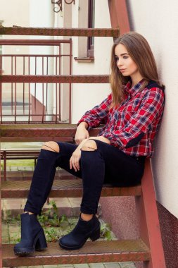 Sonbahar gün siyah pantolon ve gömlek merdivenlerde oturan siyah uzun saçlı büyük mavi gözlü güzel çekici genç çekici kız