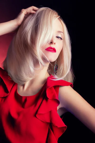 Hermosa sexy elegante mujer rubia llamativa con labios rojos maquillaje brillante en un vestido rojo en el estudio sobre un fondo negro —  Fotos de Stock