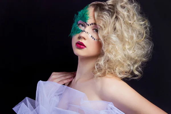 De mooie jonge vrouw in een groene mysterieuze Venetiaans masker een Nieuwjaar Carnaval, Kerstmis maskerade, een dance club, geheime night party, met mooie make-up — Stockfoto