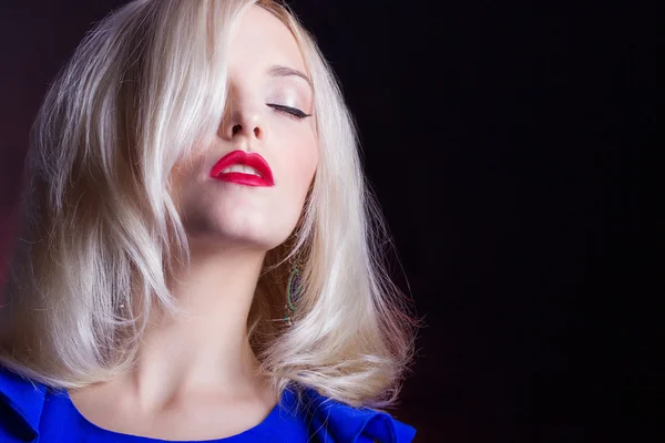 Elegante mooie vrouwen blonde met rode lippen in een blauwe jurk in de Studio — Stockfoto