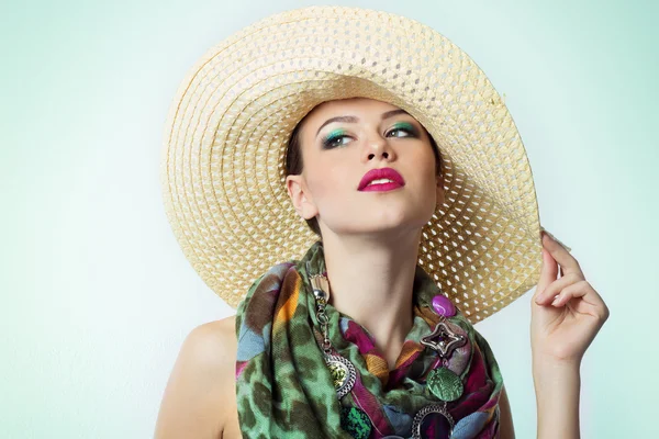 Hermosa joven con un sombrero de maquillaje brillante con color hermosa bufanda costosa en el cuello sobre fondo blanco en Studio —  Fotos de Stock