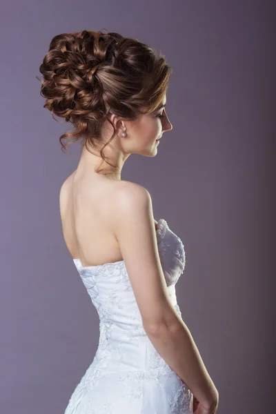 Retrato de una hermosa novia de mujer suave y elegante en un vestido blanco con un hermoso peinado y maquillaje —  Fotos de Stock