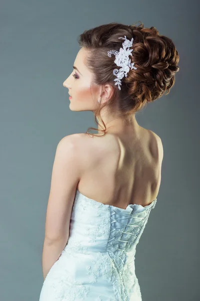 Retrato de una hermosa novia de mujer suave y elegante en un vestido blanco con un hermoso peinado y maquillaje —  Fotos de Stock