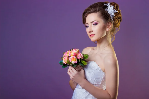 Ritratto di una bella sposa donna gentile ed elegante in un vestito bianco con una bella acconciatura e trucco — Foto Stock