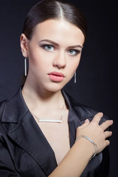 Hermosa joven con hermosas joyas costosas con estilo, collar, pendientes, pulsera, anillo, filmación en el estudio — Foto de Stock