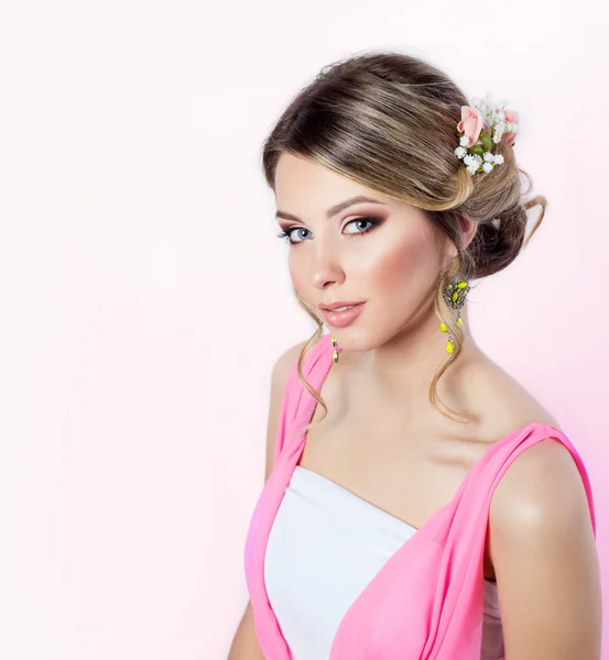 Delicada imagen de una hermosa chica mujer como una novia con peinado de maquillaje brillante con flores rosas en la cabeza en un vestido largo de color rosa — Foto de Stock