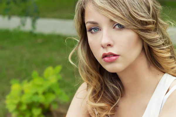 Portrait of beautiful sexy blonde girl in a Park with large plump lips — Stock Photo, Image