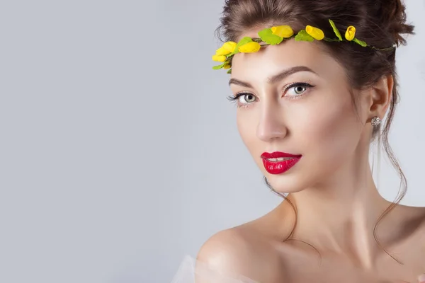 Hermosa joven sexy elegante mujer con labios rojos, hermoso cabello con una corona de rosas amarillas en la cabeza con hombros desnudos, el camino para la novia en una boda — Foto de Stock