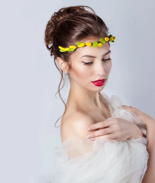 Mulher elegante sexy nova bonita com lábios vermelhos, cabelo bonito com uma grinalda de rosas amarelas na cabeça com ombros desnudados, o caminho para a noiva em um casamento — Fotografia de Stock