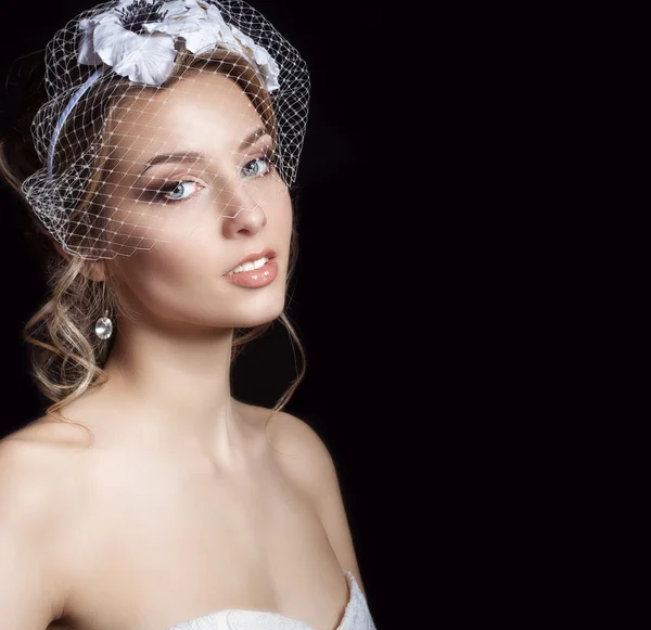 Boldog szép menyasszony nő szőke lány fehér menyasszonyi ruha, a haj és világos make-up a fátyol a szemét és a virág a hajában a stúdióban — Stock Fotó