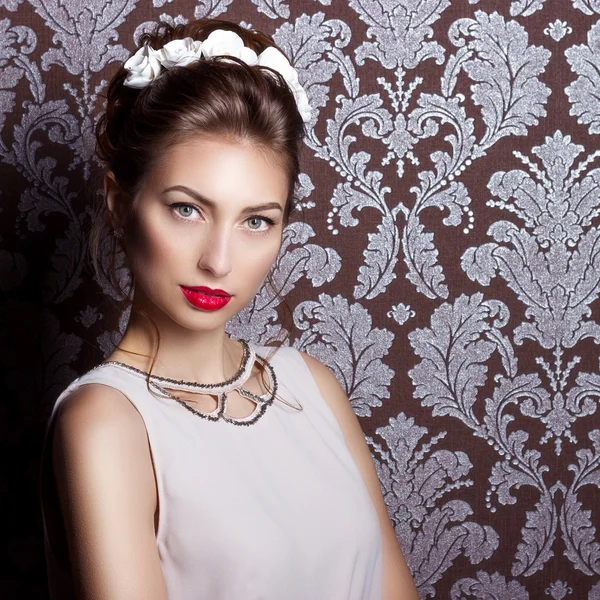 Bella giovane donna sexy elegante con le labbra rosse, bella acconciatura elegante con fiori bianchi nei capelli, la strada per la sposa a un matrimonio — Foto Stock