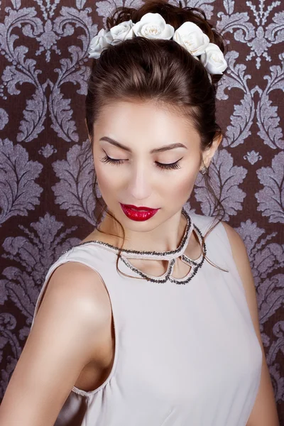 Beautiful young sexy elegant woman with red lips, beautiful stylish hairstyle with white flowers in her hair, the way for the bride at a wedding — Stock Photo, Image