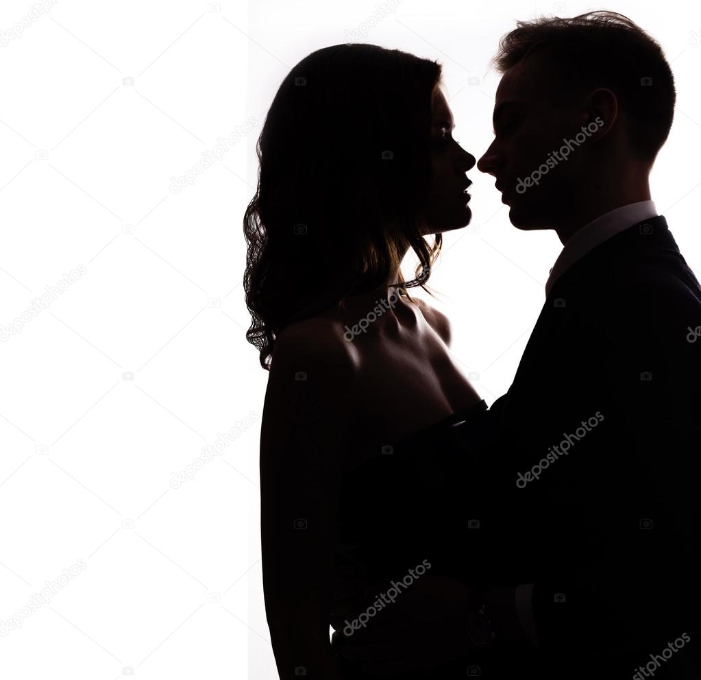 Silhouette of a happy couple in love kissing on white background