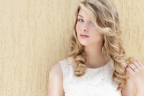 Portrait of a beautiful sexy smiling happy girl with big full lips with blond hair in a white dress on a sunny bright day — Stock Photo, Image