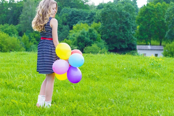 青空に夏の日にカラフルな風船で遊ぶ美しい少女 — ストック写真