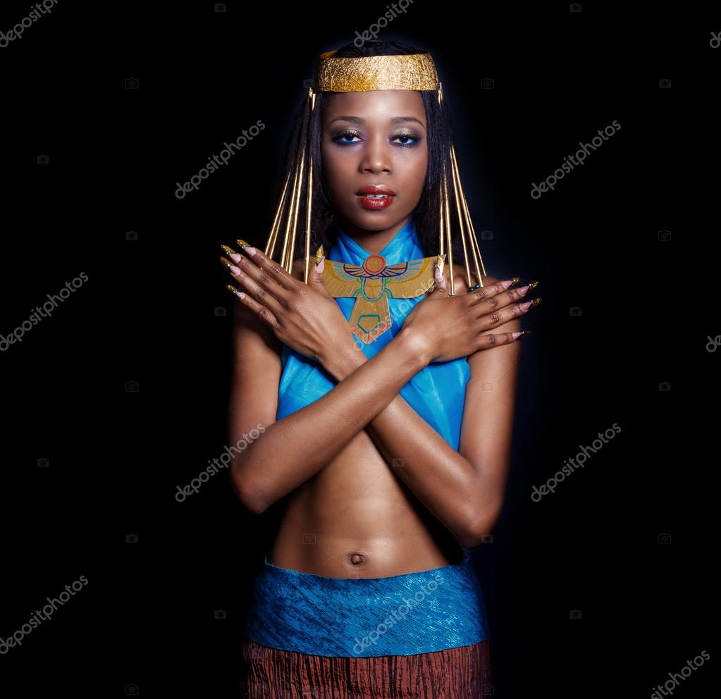 En vakker, mørkhudet, svart kvinne i bildet av en egyptisk dronning med  røde lepper. Lys sminke viser lange negler. – stockfoto © Tanyunya2014  #69846801, image size:1023x992