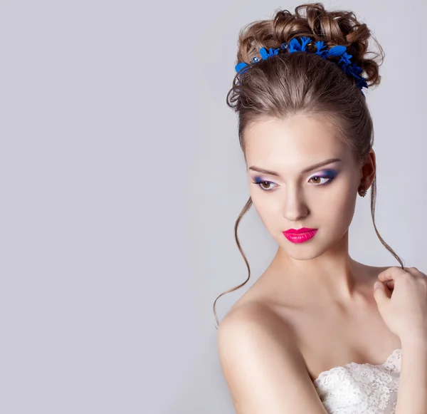 Retrato de moda de uma linda garota atraente com uma suave e elegante penteados de casamento à noite maquiagem alta e brilhante, com flores no cabelo e brincos grandes — Fotografia de Stock