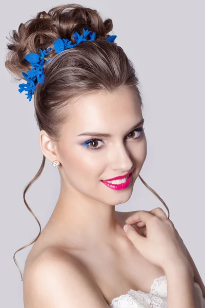 Retrato de moda de una hermosa chica atractiva con un suave y elegante peinado de boda por la noche maquillaje alto y brillante, con flores en el pelo y pendientes grandes —  Fotos de Stock