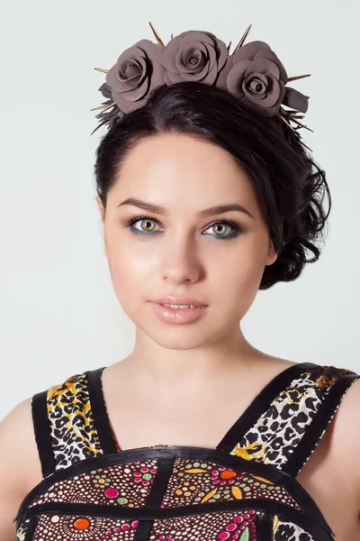 Portrait of a girl brunete with hair beam with a delicate make up and a wreath in her hair from black roses with thorns rock — Stock Photo, Image