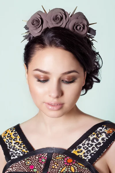Retrato de una chica morena con viga de pelo con un delicado maquillaje y una corona en el pelo de rosas negras con espinas rock —  Fotos de Stock