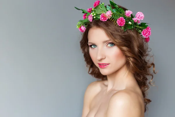 Sweet sweet beautiful sexy young girl with a wreath of flowers on her head, with bare shoulders with beauty makeup soft pink lips , a cute look at the camera — Stock Photo, Image