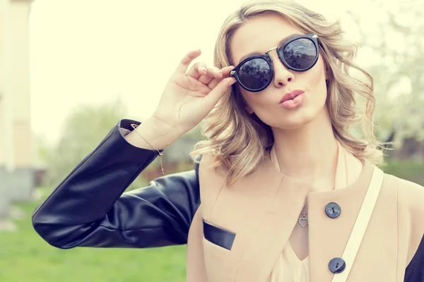 Beautiful young sexy girl in sunglasses walking on a bright sunny summer day on city streets — Stock Photo, Image