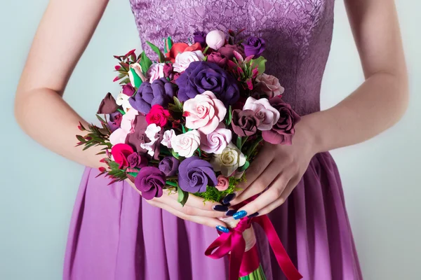 Strauß für die Braut, Mädchen im lila Abendkleid mit einem großen Strauß bunter Rosen in der Hand — Stockfoto