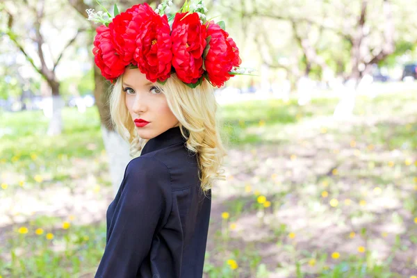 Portrait de belle fille blonde sexy avec une couronne de pivoine se promène dans le jardin par une journée ensoleillée — Photo