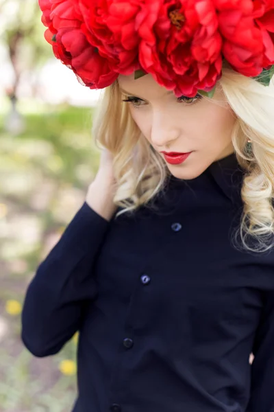 Portrait de belle fille blonde sexy avec une couronne de pivoine se promène dans le jardin par une journée ensoleillée — Photo