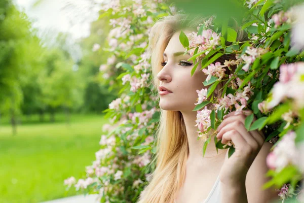 Beautiful young sexy girl in flowers in the Park — Stock Photo, Image