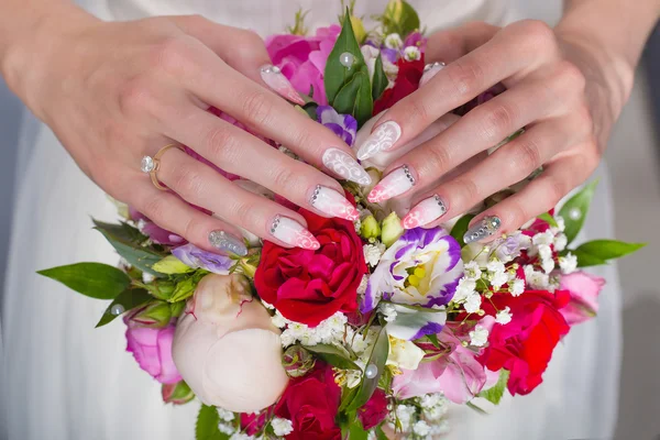 Beautiful wedding bridal bouquet of roses and peony with her hands on the bouquet , long acrylic nails with rhinestones for the bride — Stock Photo, Image