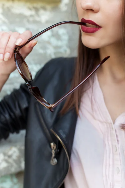 Girl with red lipstick in a black leather jacket sunglasses bit — Stock Photo, Image