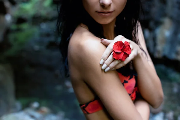 Saçları ve karanlık yağmur ormanlarında kayaların arasındaki onun parmağına yüzük çiçek ıslak bir mayo içinde siyah saçlı güzel seksi sevimli kız — Stok fotoğraf