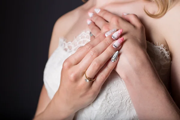 手与丙烯酸指甲和绣有精美图案和水钻的白色婚纱的美丽女孩新娘 — 图库照片