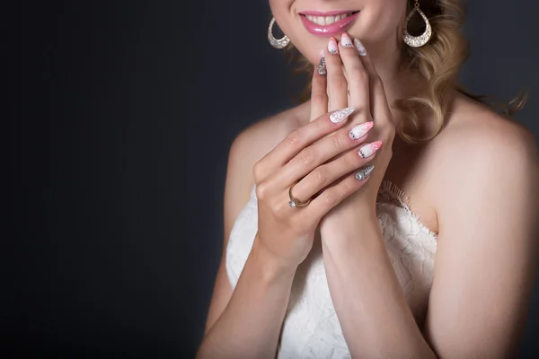 Mão noiva menina bonita em vestido de noiva branco com unhas acrílicas e padrão delicado e strass — Fotografia de Stock