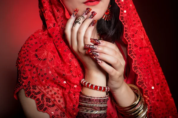 Beautiful girl in the image of Indian woman in a red sari with beautiful patch acrylic nails in oriental style in the studio — Stock Photo, Image