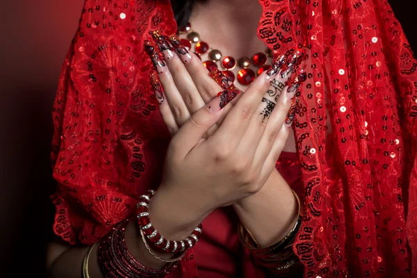 Hermosa chica en la imagen de la mujer india en un sari rojo con hermosas uñas de acrílico parche en estilo oriental en el estudio — Foto de Stock