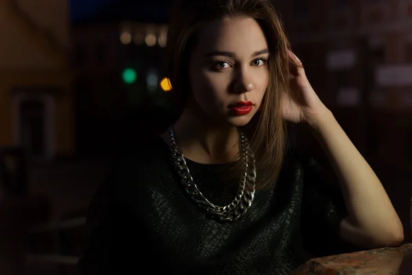 Vacker sexig tjej med stora läppar med rött läppstift på en stadsgata på natten nära lyktan — Stockfoto