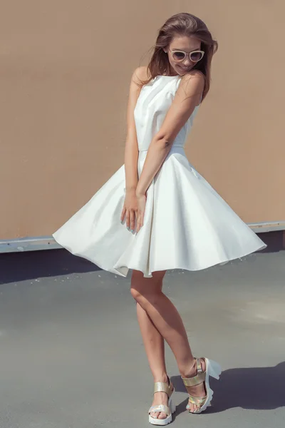Bardzo słodki piękna dziewczyna w jasny biały ubierać się w modne buty i okulary przędzenia na dachu — Zdjęcie stockowe