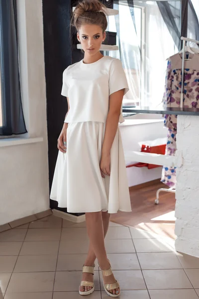 Hermosa mujer joven sexy en hermoso vestido blanco de moda en el estudio posando para la cámara de fotos de moda para el catálogo de ropa —  Fotos de Stock