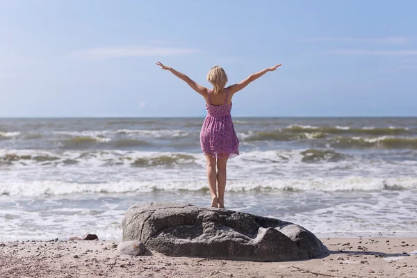 Młoda piękna szczupła dziewczyna stojąc na plaży w słoneczny letni dzień, silny wiatr na morzu — Zdjęcie stockowe