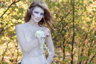 güzel güzel nazik zarif Peri Peri bir çiçek taç ve ışık elbise ormandan erken güneşli bir günde yürür.