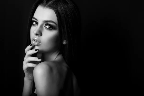 Retrato de moda en blanco y negro de hermosa chica joven sexy con labios llenos maquillaje brillante negro ojos ahumados con pelo largo negro en Studio sobre un fondo negro — Foto de Stock