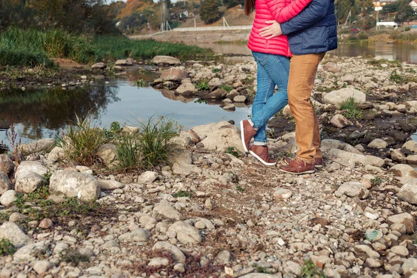 Voeten liefdevolle gelukkig paar aan de oever van het meer in de buurt van het water — Stockfoto