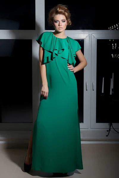 Beautiful sexy elegant long-legged girl in a long green evening dress with evening hairstyle and bright make-up, new year's evening look — ストック写真