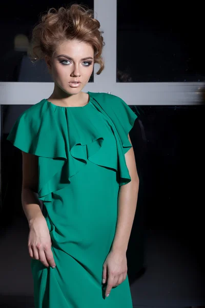 Beautiful sexy elegant long-legged girl in a long green evening dress with evening hairstyle and bright make-up, new year's evening look — Stok fotoğraf