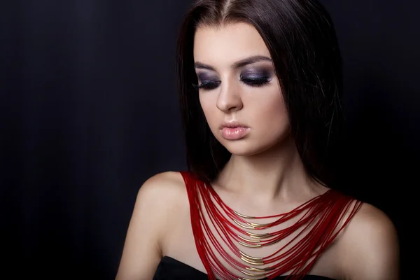 fashion portrait of beautiful young girl with a bright evening make-up for an evening look with beautiful bright jewelry