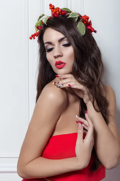 Christmas elegant fashion woman. Xmas New Year hairstyle and makeup. Gorgeous Vogue style Lady with Christmas decorations on her head, baubles, professional makeup, red lipstick long red evening dress — ストック写真